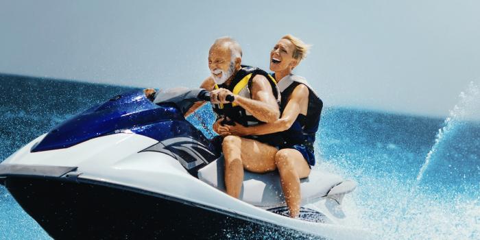 Senior couple riding jetski in ocean