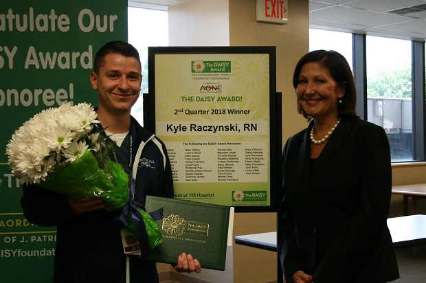 male and female nurse smiling with flowers