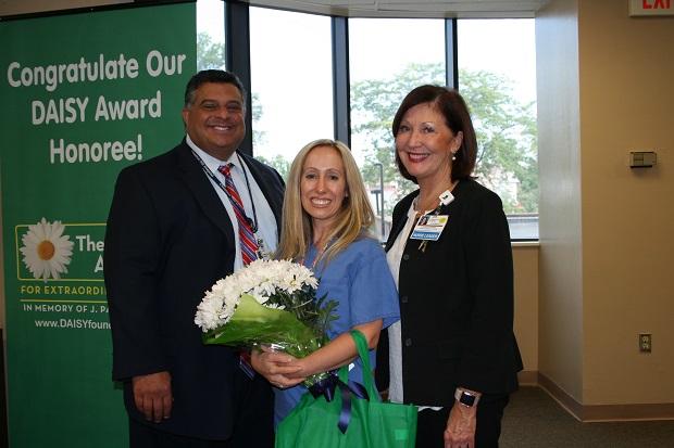 male and two females smiling for nurse award