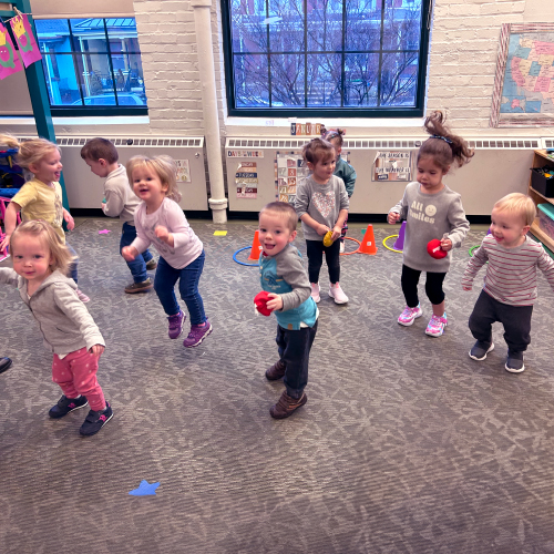 Preschool children dancing in a group as part of an exercise activity to promote healthy habits.