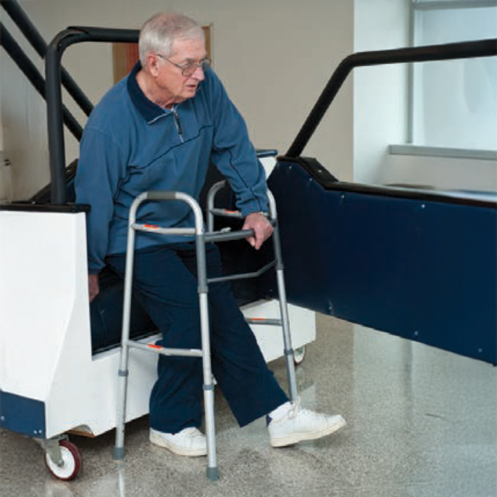 A person transfers into car by backing up against car and reaching back for the car seat before lowering into sitting position.