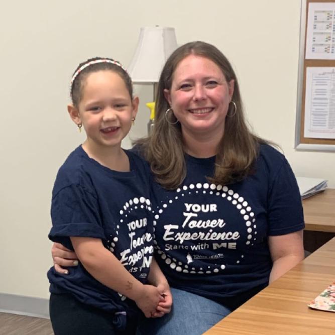 A mother and child behind the desk at 'Take Your Child to Word Day' at Tower Health