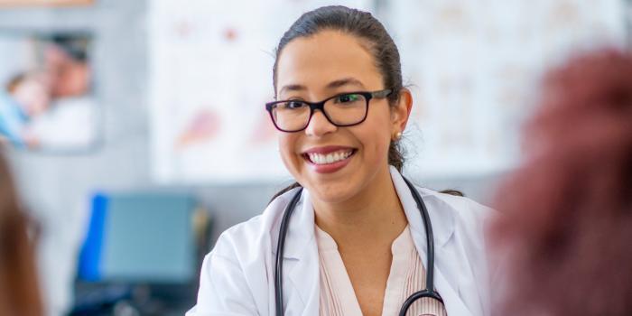 doctor smiling with two patients in front of her