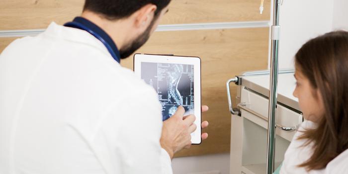 Doctor showing x-ray to female child and mother