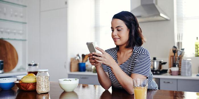 woman in kitchen looking at phone