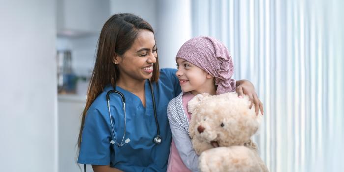 Young cancer patient smiling with medical provider