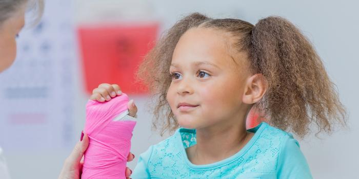 Girl with pink cast and urgent care provider