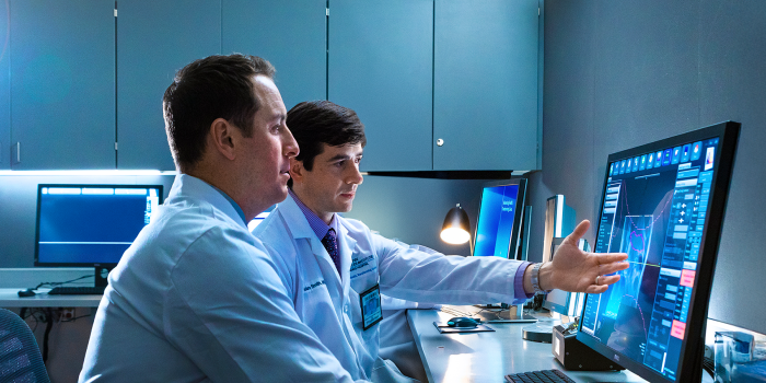 Radiation oncologists reviewing results on computer monitor