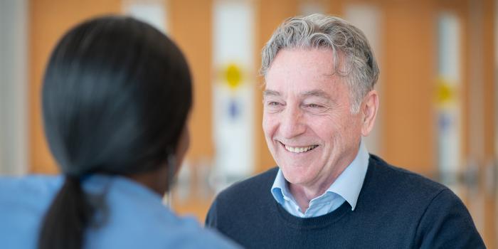 Senior male patient smiling at female medical provider