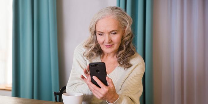 Senior woman using smartphone in house