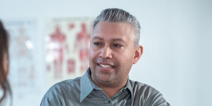 Middle-age male Hispanic patient smiling at medical provider