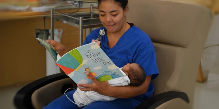 Ariana Thomas, RN, reads to a baby in Reading Hospital's Level III NICU.
